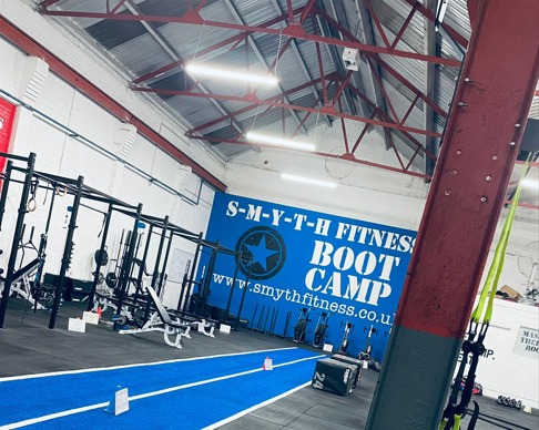 Inside the Smyth Fitness Boot Camp gym in Loughborough, with squat racks and a turf track