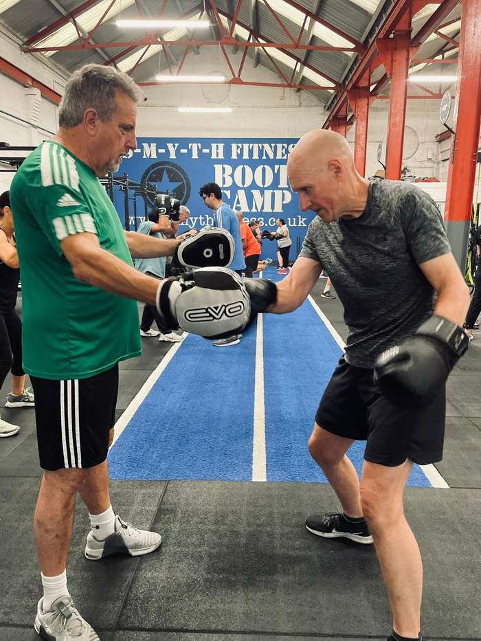 Coach holding focus pads for a member during a boxing session at Smyth Fitness