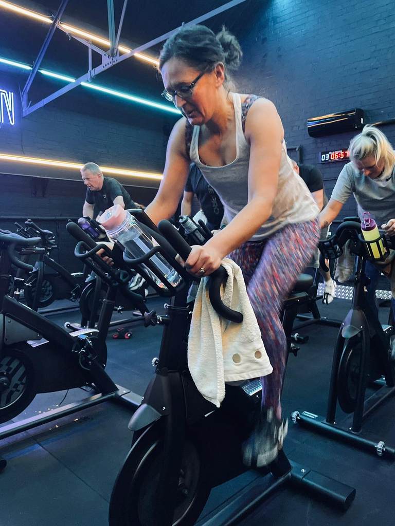 Woman riding a spin bike during an indoor cycling class